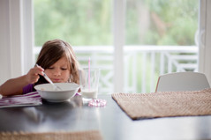 Small child eating cereal at a table
