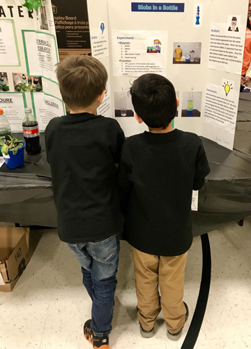 Children reading science fair projects at Enders Salk