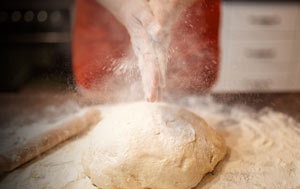 Bakery report - hands clapping flour over bread dough