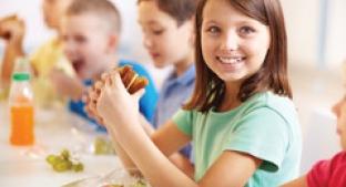 young Girl smiling eating lunch