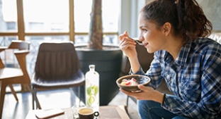 Q3 Trading Statement Fy24 Lady eats yoghurt over a low table