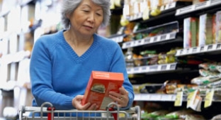 Asian woman reading on-pack labeling