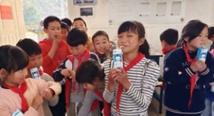 Two smiling Chinese school children eating lunch