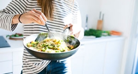 Woman cooking a healthy meal in a wok