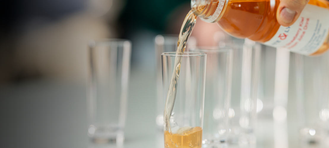 Orange liquid falling in clear glass